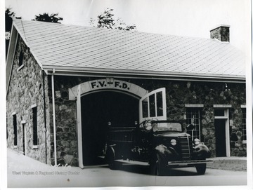 A fire truck is in front of the new Firehouse which was built by Works Progress Administration in Pendleton County, West Virginia.