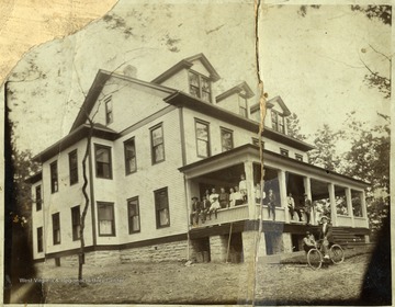 People standing and seated on the porch of the Club House at Eccles.
