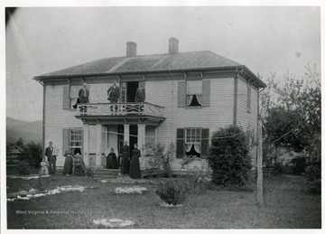'Seated on rocking chair by front porch: Allen Dyer, grandson of James Dyer who was captured by indians in Fort Seybert Massacre.  In chair on the porch: Mrs. Martha Dyer (wife of Allen).  On roof porch are three of Dyer's sons; from left; Ed R. Dyer, Pent Dyer and Charlie Dyer. This is the home of Allen and Martha Dyer.  This picture was probably taken shortly before the death of Martha in 1894.  Home is located at Fort Seybert on right side of road just after crossing bridge over South Fork River.  Note: September of 1977; The appearance of this house has been greatly changed because of later remodeling.'  