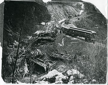 Men are cleaning up the wreckage of the train.