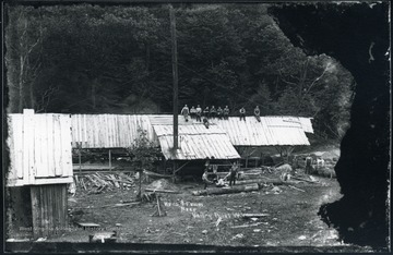 Workers standing and sitting outside of Hess and Frum sawmill at Preston County.