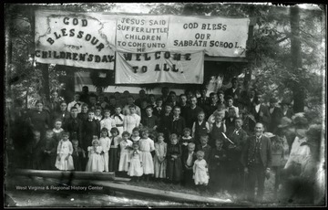 Signs says: 'God bless our children's day', 'Jesus said suffer the little children to come unto me'. 'God bless our sabbath school'. 'Welcome to all'