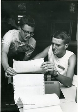 'Idaho's representatives, Dick Goldberg (left) of Sun Valley and Jim Willms of Gooding, are operating an IBM 1620 electronic digital computer at the National Youth Science Camp, deep in the Allegheny Mountains near Bartow, W. Va.  The camp brings together the top two science-minded students from every state for lectures and seminars at research and professional levels, field trips to study the state's natural wonders, and side trips to the National Radio Astronomy Observatory at nearby Green Bank and the state and nation's capitols.  The state of W. Va. sponsors the three weeks' camp, which ends July 17th.'
