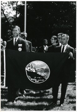 'Montana's representatives, Benjamin Marchello (left) of Billings, and R. L. Erion of Missoula, unfurl the state flag at the National Youth Science Camp deep in the Allegheny Mountains near Bartow, W. Va.  The State of West Virginia and the University bring together the two top science-minded students from every state for three weeks of lectures and seminars at the research and professional levels, field trips studying the state's natural wonders, and side trips to the National Radio Astronomy Observatory at nearby Green Bank and the state and nation's capitols.'