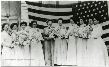 View of ladies standing in front of American flag.