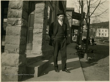 Mr. W.B. Haught is standing in front of a building in Monongalia County, West Virginia.