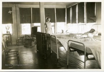 Nurse standing beside a child in bed.