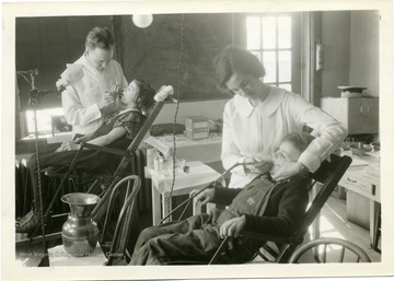 Dentist and dental assistant at work on children's teeth.