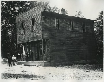 View of men standing on porch of building.