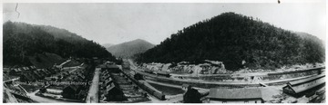 A panoramic view of the homes on the hillside and the train tracks that run through the little community.