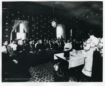 Group of people are attending a demonstration of Domestic Science.