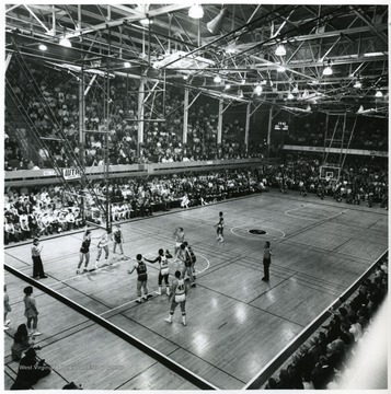'Pitt 92, West Virginia 87; March 3, 1970; The final game in historic Mountaineer Field House found West Virginia losing to Pitt, 92-87, but finishing a 42 year span with an overall record of 347-77 in the Beechurst Avenue barn.  Two stars who played in the Field House when it first opened in 1928 were honored at halftime--Dr. Marshall (Little Sleepy) Glenn, former West Virginia athlete and coach, and Charley Hyatt, then All-American basketball star at Pitt.  Athletic Director Robert N. (Red) Brown presented plaques to Hyatt, Glenn, T. Edward Davis (who coached Salem College in the first Field House game in 1928), and Mickey Furfari who accepted Walter L. (Bill) Hart, columnist and former editor and sports editor of the Morgantown Dominion News.  A speech by Brown on Field House highlights was the feature of the special halftime ceremony.'