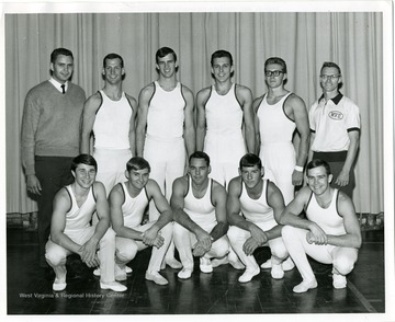 Group portrait of the 1965-66 West Virginia University Gymnastics Team. 'Front Row: left to right: Jim Bays, Ed Cross, Ron Curfman, Danny Deem, and Ed Ehler. Back Row: Left to right: Jim Sybert, Charlie Carmichael, Jack Carter, Ken Musko, Mike Knaggs and Coach Bill Bonsall. Taylor Publishing Company, Job Number 07206, Picture Number 2, page Number 214, West Virginia University, Morgantown, West Virginia.'