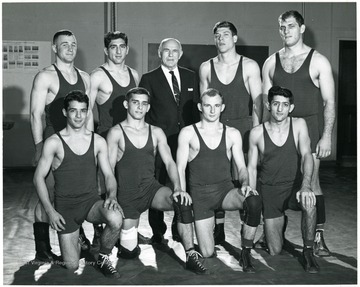 'Southern Conference Champs.  Kneeling:  Don Check, Bill Meaci, Francis Pavlovich, Capt. Jim Jioio.  Standing:  Jerry Gooden, Bart Biondolillo, Coach Steve Harrick, John Luckini, Mike George.'