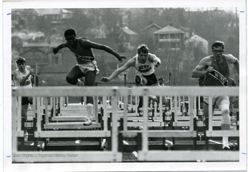 Track members of West Virginia University and Virginia Tech compete in the hurdles. 