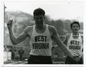 Mike Mosser crosses the finish line before Carl Hatfield during a Cross Country race.