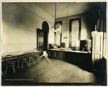 Office in Woodburn Hall featuring telephone, typewriter, electric or gas lighting, safe, and roll-top desk, along with other standard furnishings.
