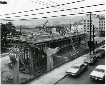 'Scene of a pigeon overlooking construction of the Walnut PRT Station, Knapp Hall in background, Woodburn Hall farther in distance.'