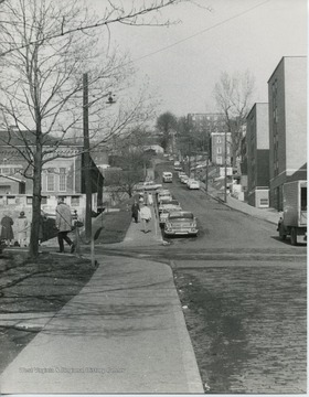 View of students walking around North High Street.  Fraternity houses on left side of street.  Ruins of Mechanical Hall II on front left.  Girls dorm, Boreman, on right.  Men's Halls, later changed to Boreman when girls were to live in them.  