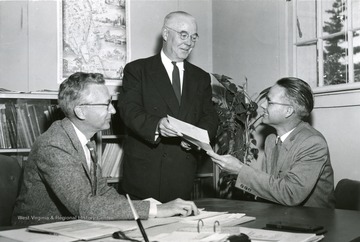 Leroy Myers, right, graduate student at Michigan State University, has received a $3,000 annual fellowship for study in the field of city planning and urban renewal, according to Harold W. Lautner, left, head of the M.S.U. department of landscape architecture and urban planning. On behalf of the donor, the Sears-Roebuck Foundation, J.J. Roden, manager of the Sears store in Lansing, Mich., presents the fellowship certificate to Myers. An assistant professor of geography at West Virginia University, Myers will do advanced study at M.S.U. for the coming two years. Four other individuals studying city planning and urban renewal at other universities received similar awards.