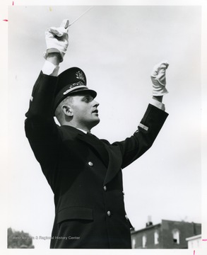 Budd Udell, in uniform and white gloves, directing the band.