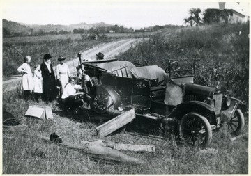 Green family around Charles Green's 1918 Ford.  From left to right:  Violet Green, Lily Green, Rosa Green, Julia Goodluck, Charles Green, and Benton Green.  Oscar Goodluck is behind the car, wearing a hat.
