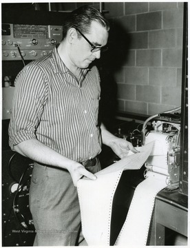 Man studying readout from a machine.