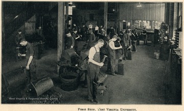 Male students working hard in a forge shop.