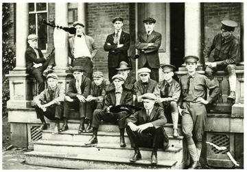 A group of male students gathered on a porch.  