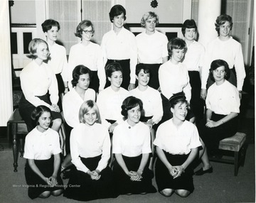 Members of Program Board of Associated Women Students pose for a photo op in Elizabeth Moore Hall; white top and dark bottom are worn by all.