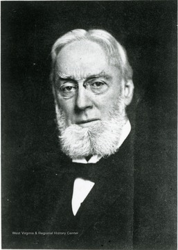 Portrait of an unidentified faculty, he is wearing gray hair and full beard, shown here with a bow tie, vest and jacket. 