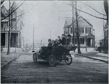 Female students riding in a Model T at the intersection of Pleasant and Spruce Streets.