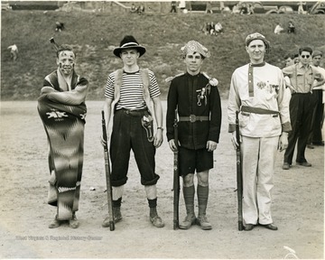 Four R.O.T.C. cadets participated in Old Clothes Parade pose with guns.  