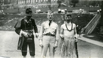 Two cadets in costume pose with a uniformed cadet.
