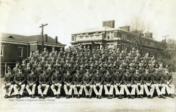 The cadets of company C sit on bleachers with officers for a group portrait near Oglebay Hall.