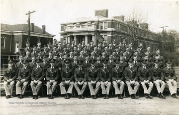 The cadets of company E sit on bleachers with officers for a group portrait near Oglebay Hall.