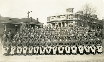 The cadets of company H sit on bleachers with officers for a group photo near Oglebay Hall. 