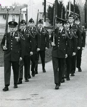 Members of Pershing Rifle Drill Team march: S. Schmidt, T. Bortner, V. Alvis, J. Patton, R. Ferrell, B. Hathaway, R. Miller, F. Aurenty.