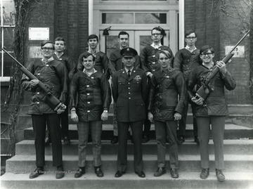 Members of Army ROTC rifle team pose with an officer in front of Woodburn Hall: Bottom Row--Brent Jones, William Schetzel, SSG Robert Mcnickle, Richard Jones, James Dunn, Top Row--Burke Pinnell, William Truxal, Alexander Fischer, William Lobb, Gary Lund.