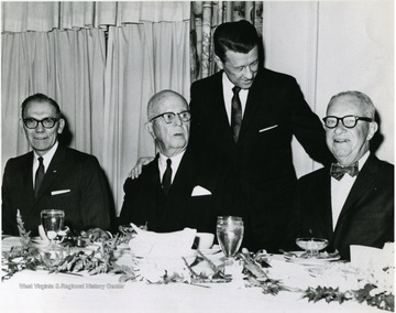 Dr. Harry Heflin is standing and on the left is Martin Piribek, the president of First National Bank.