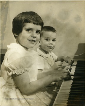 His daughter and son at a piano.