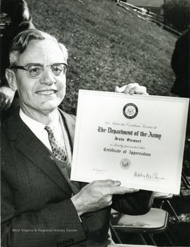 President Stewart holds a certificate of appreciation awarded to him by the Department of Army.