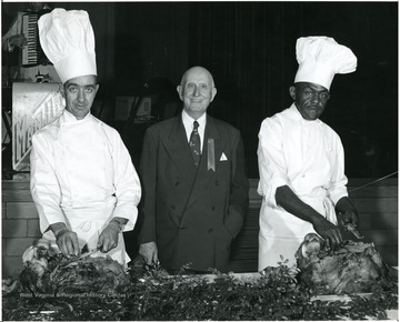 Sponsored by R.M. Davis, standing in the middle, flanked by two chiefs carving meat.