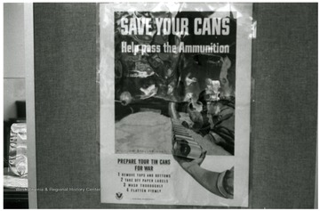 Exhibit in second floor gallery of Mountainlair. Poster says, 'Save your cans, help pass the ammunition. Prepare your tin cans for war, 1) remove tops and bottoms, 2) take off paper labels, 3)wash thoroughly, 4) flatten firmly.'