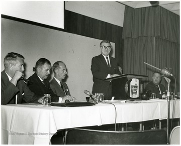 'Peter Muirhead, associate U.S. commissioner of Education, is shown speaking at the Sept. 12, 1967 seminar on 'The State University.'  Also shown, from left to right, are: Keith Glancey, WVU Prof. of Education; Thomas Isaack, WVU Prof. of Management; Thomas Canning, WVU Prof. of Music; Ruel Foster, WVU Prof. and Chairman of English and Chairman of the semnar planning committee; and James G. Harlow, president of WVU.'