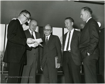 'Dr. Moody Prior, graduate department of English at Northwestern University (center) chats with seminar planning committee chairman John Ludlum, Dean of the WVU Graduate School (left); Homer Evans, Prof. of Agricultural Economics and Associate Director of the WVU Agricultural Experiment Station (second from left); Delmas Miller, WVU Prof. of Education and Chairman of Secondary Education (second from right); and Virgil Peterson, WVU prof. of English, at the Dec. 6, 1967 seminar on the Future of Graduate Education at WVU.'