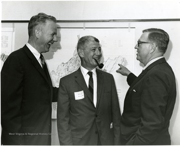 'Three main speakers of the June 28-29, 1967 symposium on 'Man and His Community' are shown including from left to right: Patrick Cusick Jr., Vice-President and General Manager of Litchfield Park Land and Development Company of Phoenix, Arizona; Edward Hollander, economist with Robert R. Nathan Associates of Washington; and Frederick Gutheim, architect and planner in Washington.' 
