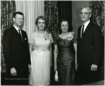 'Acting WVU President Harry B. Heflin (left), Mrs. Heflin (second from left), Dr. Irvin Stewart (right), and Mrs. Stewart are pictured just after Dr. Stewart made the main address as spokesman for the twelve professors honored at the Faculty Honors Convocation Mar. 7, 1967.'