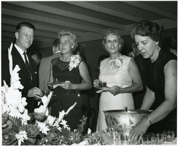'Scene from the 100th Ann. reception honoring Dr. and Mrs. Harry B. Helfin.  Facing the camera, from left to right, are: Dr. Heflin; Mrs. Gilbert Bachmann, member of the WVU Board of Governors; Mrs. Heflin; and Mrs. Ernest Nesius.'