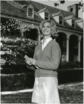 'Jeanne Erwin, Parents: Mr. and Mrs. Eugene Erwin. Senior Physical Education major. Activities: Twin Towers Residence Hall staff member, and Physical Education Majors Club.' In the background is E. Moore Hall.